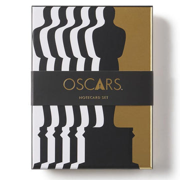 Notecard set packaging with Oscar statue silhouette and 'OSCARs' text on a white background. Discover this best-seller and fan favorite item! Exclusive Oscars Black/White/Gold note card set of 12 with tri-fold cards 4.25 x 6 when folded, includes envelopes and sticker sheet